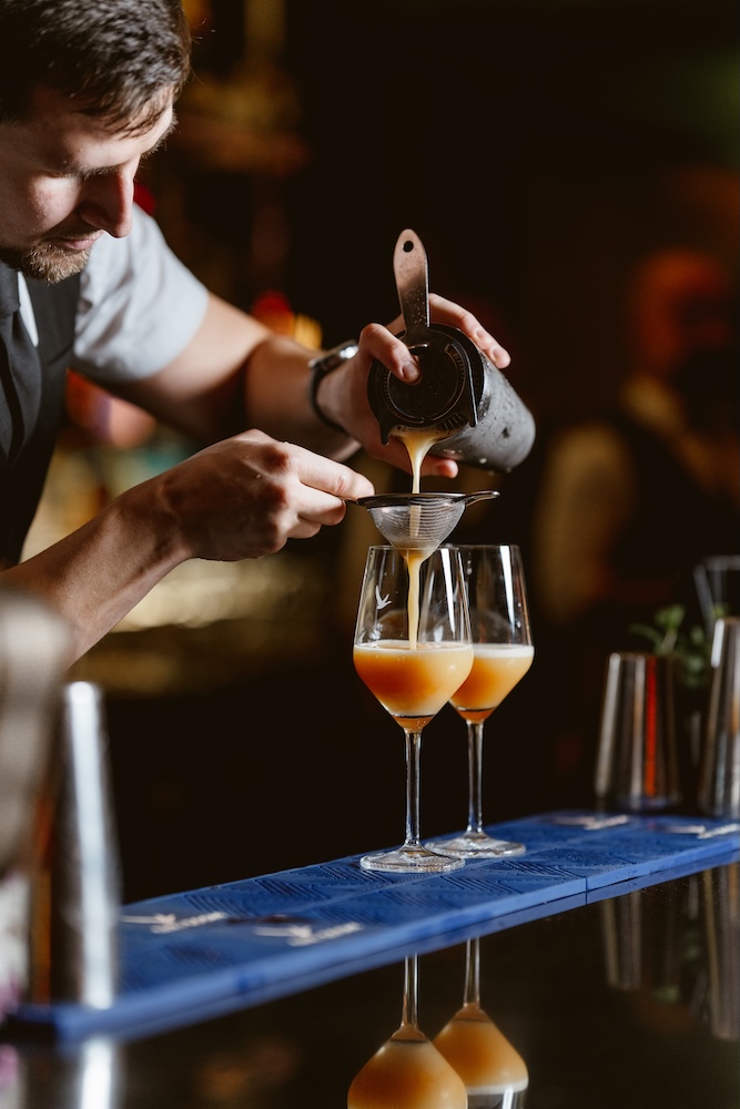 a man pouring liquid into a glass